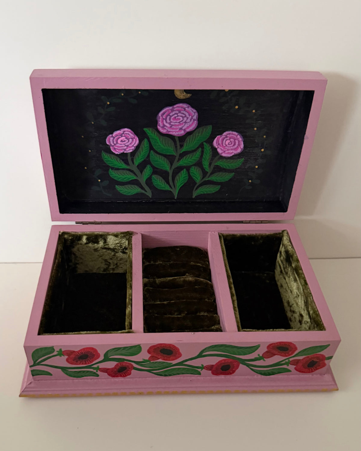 Binnenkant van roze jewelreybox met groen fluweel als voering 