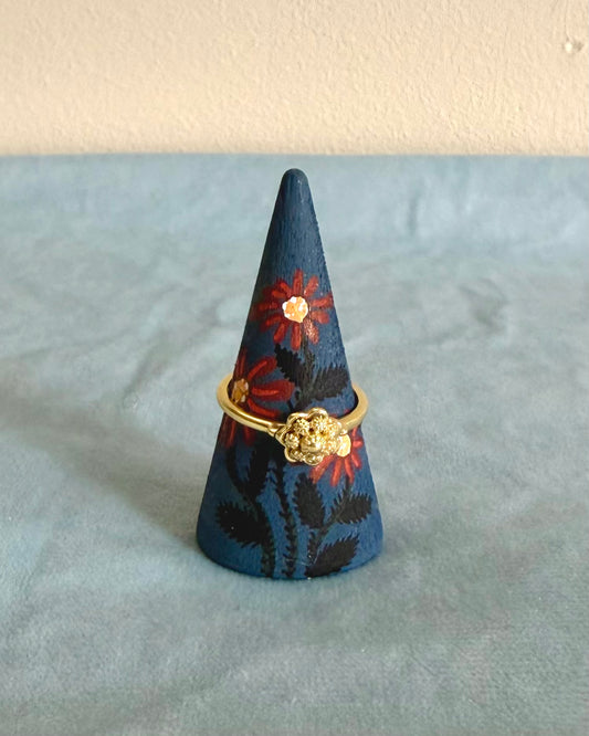 Blauwe ringkegel et rode bloemen en gouden ring 
