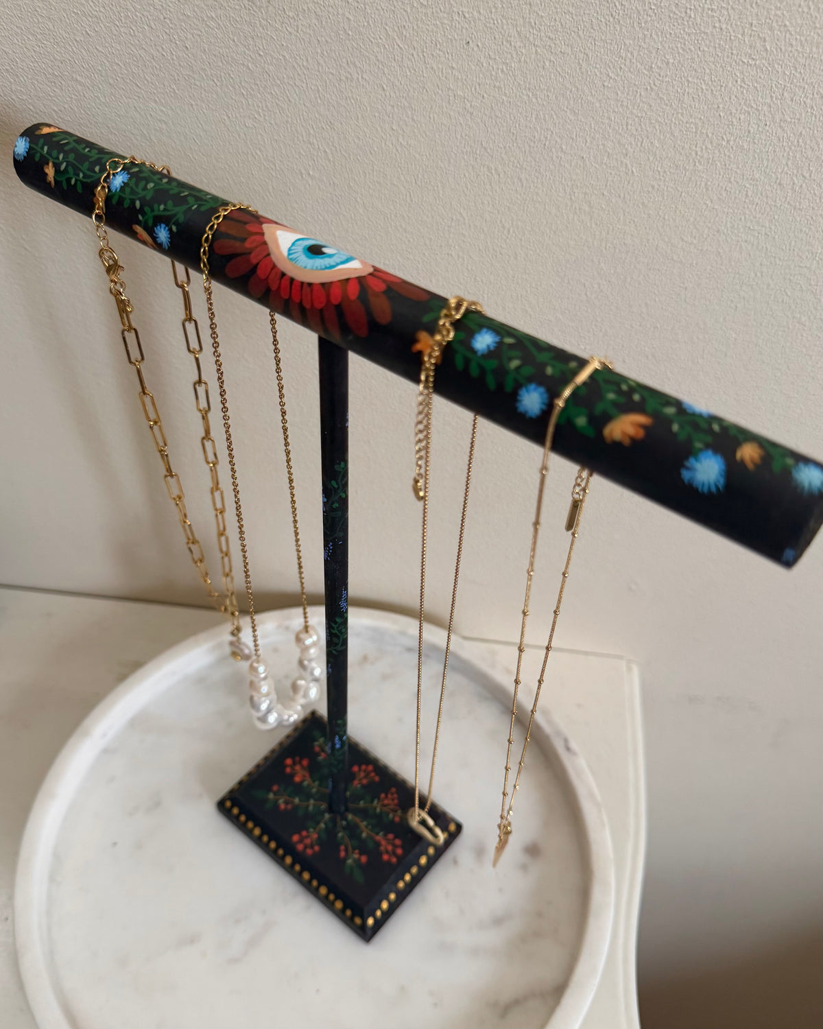 zwart rekje met kleurijke handbeschilderde bloemen voor het opbergen van kettingen en armbanden