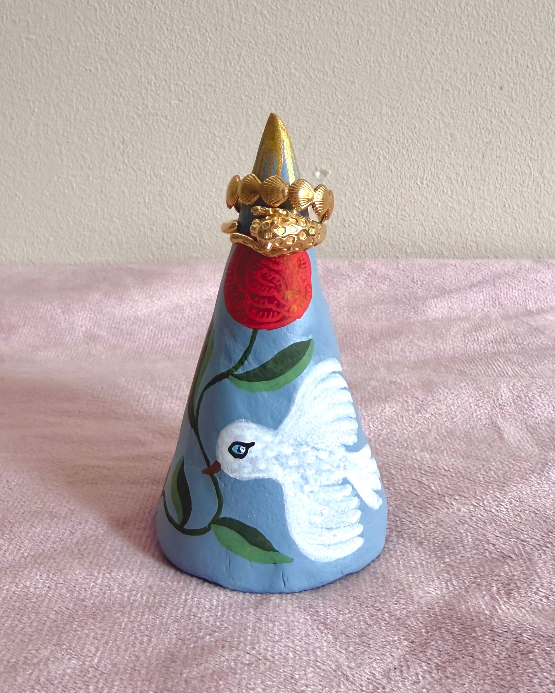 Blauwe ringkegel met witte vogel en rode rozen