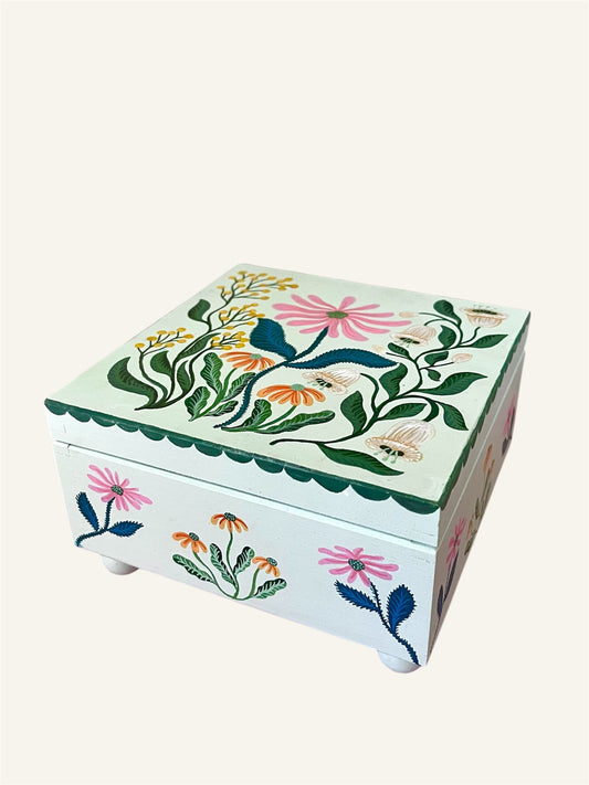 met de hand beschilderde sieradendoos met bloemen en roze fluwelen bekleding.