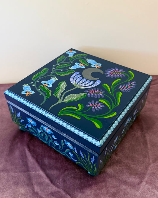 donkerblauwe sieradendoos met blauwe en paarse bloemen 