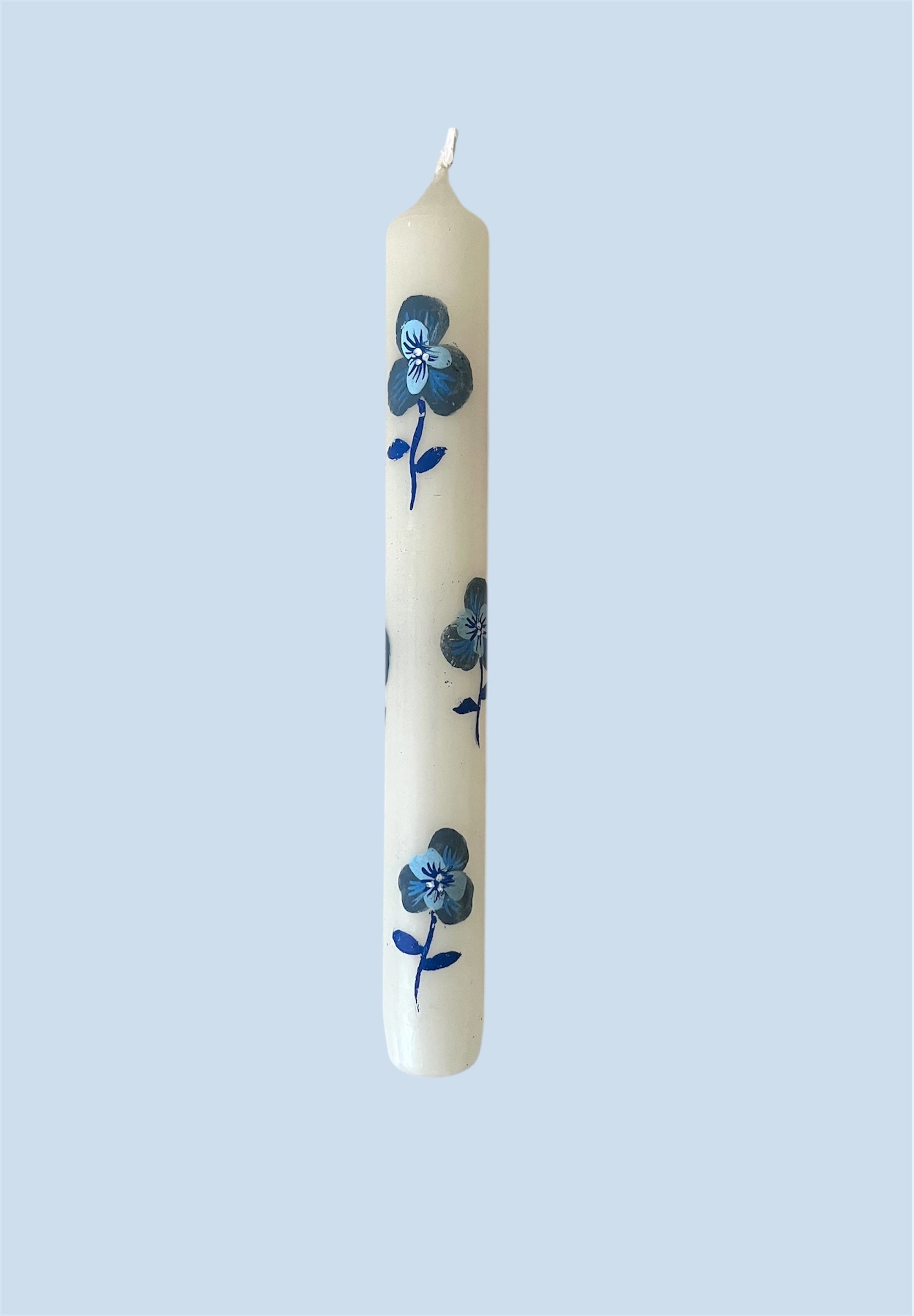witte kaars met blauwe viooltjes 
