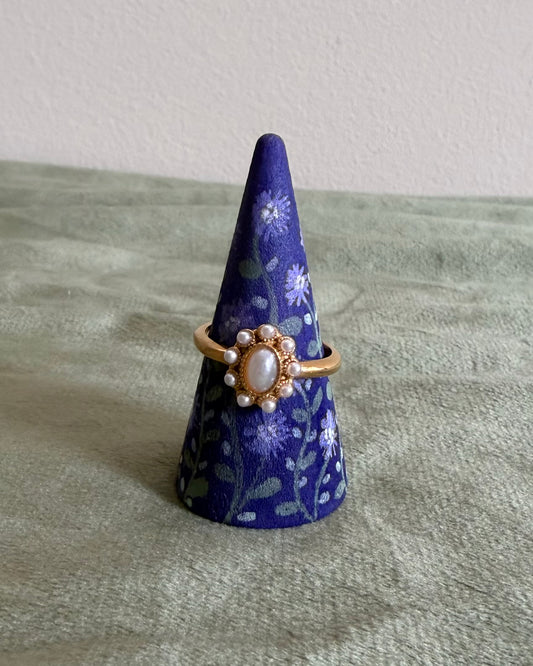 paarse ringhouder met lila bloemen en gouden ring
