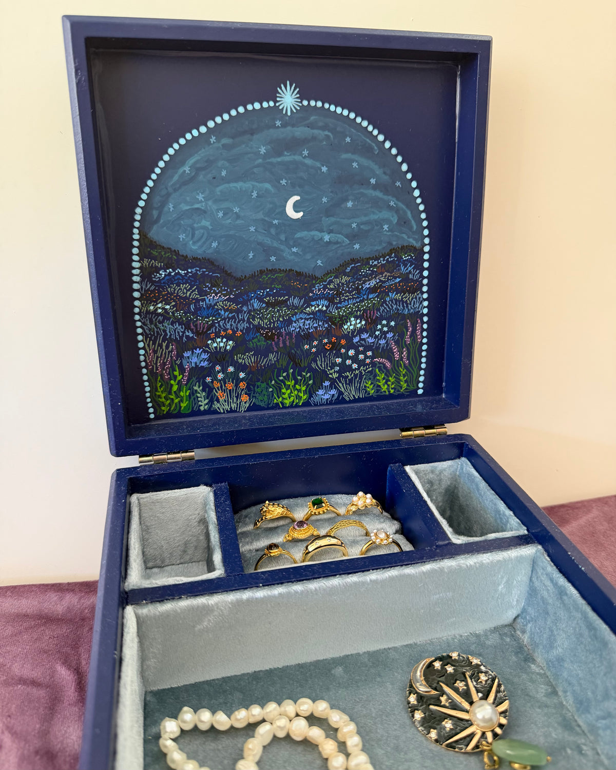 donkerblauwe sieradendoos met kleurijke beschilderingen voor vintage sieraden liefhebbers