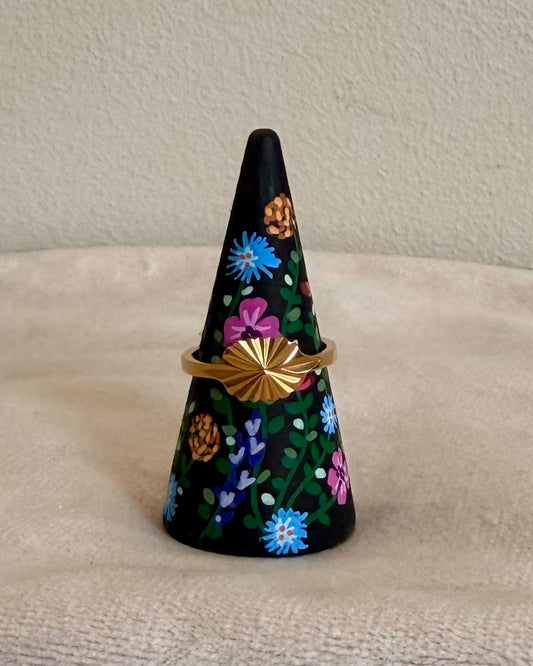 black ringholder with colorful flowers and ring